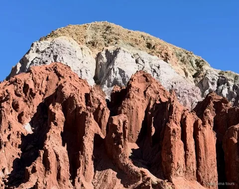 Rainbow Valley tour, layered red and green rock formations at Valle del Arcoiris