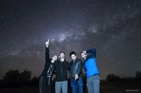 Tour astronómico en San Pedro de Atacama, guía apuntando un telescopio hacia la Vía Láctea
